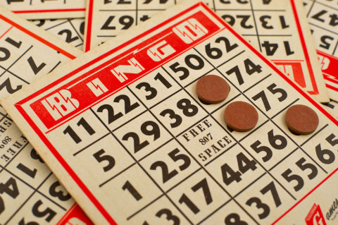 photo of bingo chips on top of several red and black bingo cards